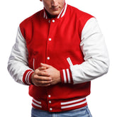 A man wearing a red and white varsity jacket with leather sleeves and a wool body, buttoned up with metal buttons.